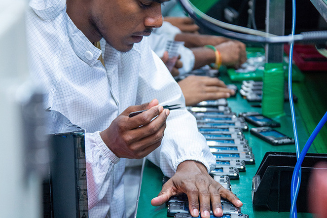 Ein Arbeiter montiert Mobiltelefone in einer Produktionsfirma in Noida, Indien. Mit der Initiative «Make in India» will Indien das grosse China bei der Industrieproduktion überholen. | © Shutterstock