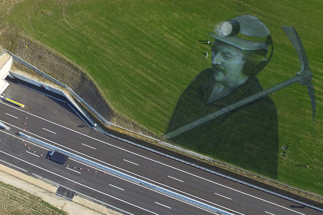 Ein 4000 m2 grosses Gras-Fresko des Künstlers Guillaume Legros alias Saype, das einen Mineur am Rand der A16 darstellt, wenige Tage vor der Einweihung des letzten Abschnitts der Transjurane zwischen Loveresse und Court im Berner Jura. | © A16